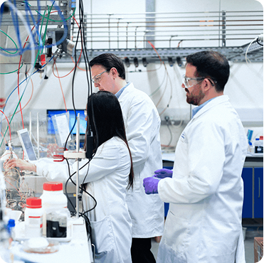 Chemists in a laboratory conducting experiments with equipment and chemicals, representing Anderson Chemical Company's expertise in sanitation and water management solutions.