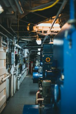 Industrial boiler room with blue machinery and piping, illustrating boiler water maintenance.