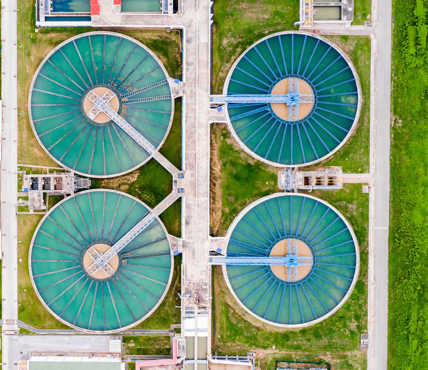 Aerial view of a water purification plant featuring four large circular pools used for water treatment.