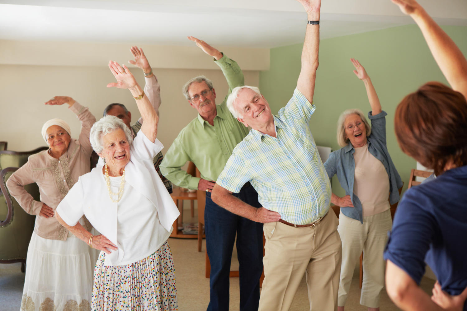Elderly residents participating in a daily stretching exercise routine at an old age home.